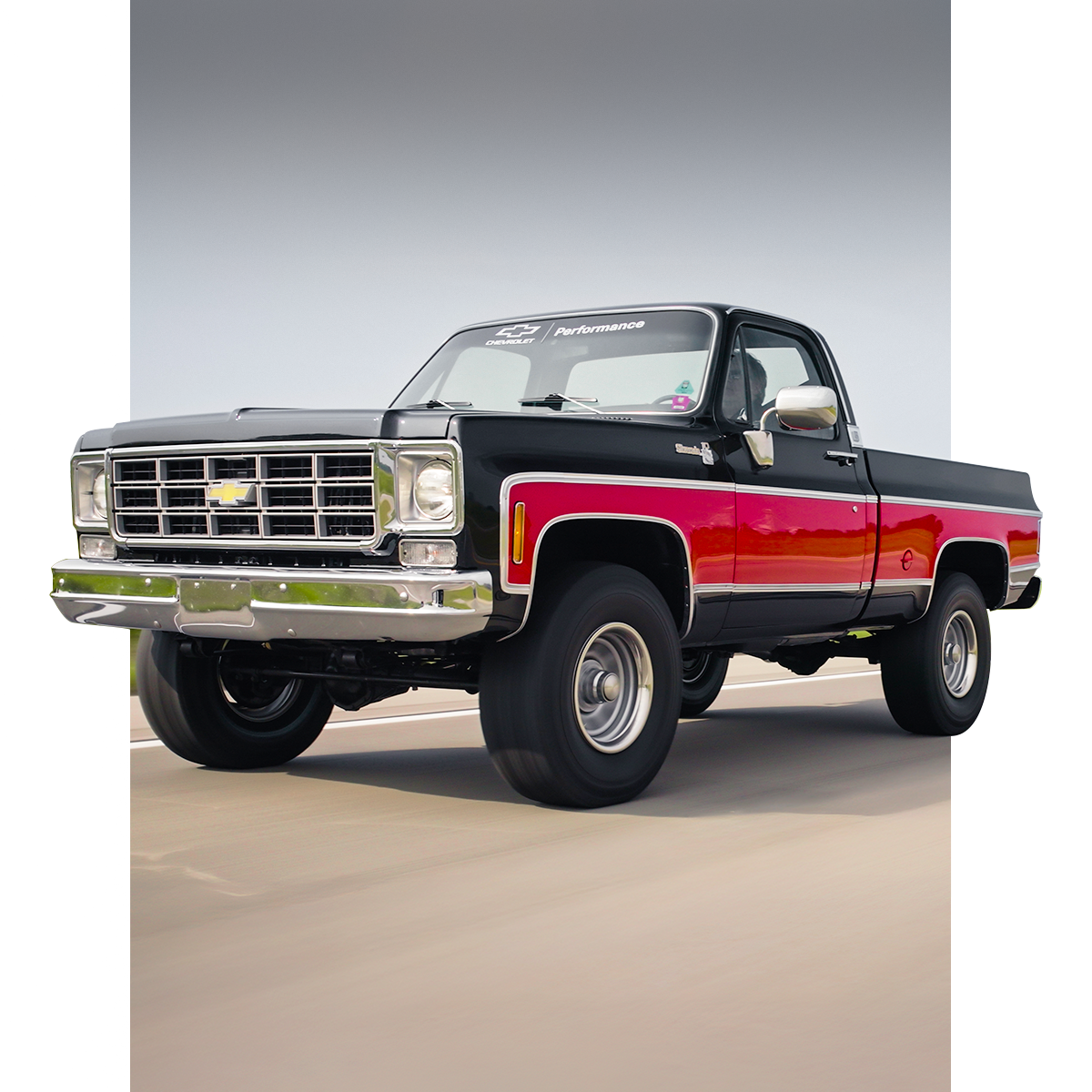 Classic Red and Black Chevrolet Silverado Pickup Truck Driving on a Road