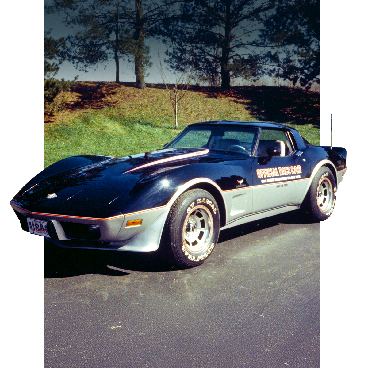 Blue and Silver Chevrolet Corvette Pace Car Parked on a Paved Road in Front of a Grassy Hill
