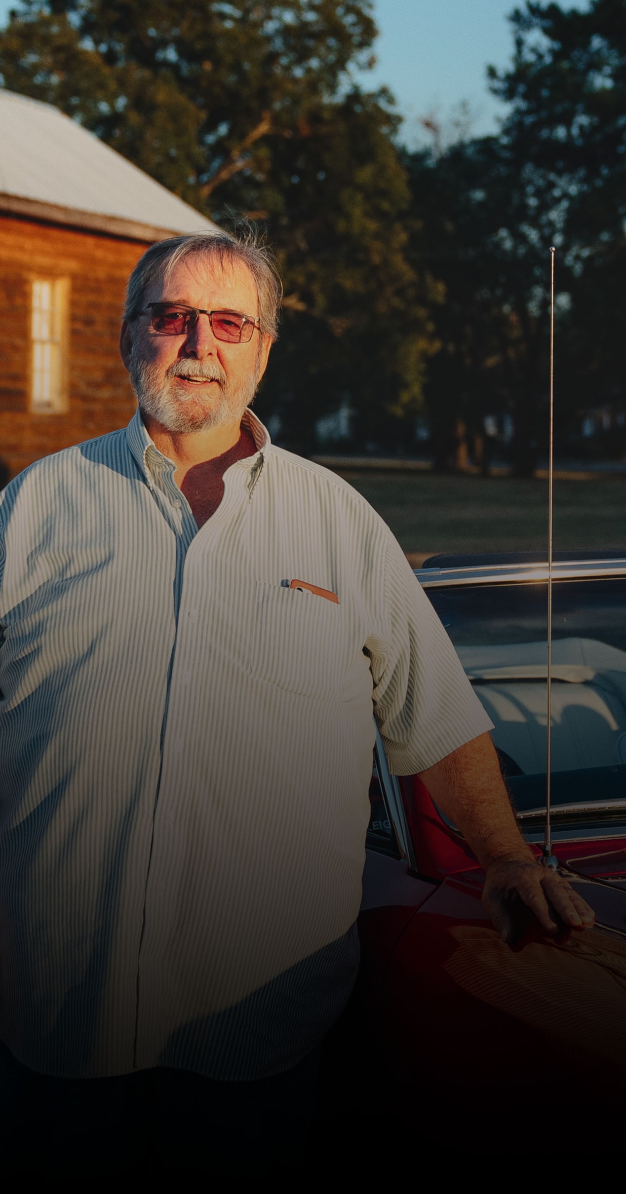 A Person Wearing a Light Gray Button-Up Shirt Standing Beside a Red 1966 Chevrolet Chevelle with Text That Reads I Was Always Tearing Stuff Apart and Putting It Back Together Above the Name Max Cooper