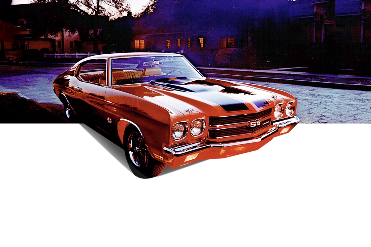 Front Three Quarters View of a Classic Orange Chevrolet Chevelle Vehicle with Black Racing Stripes Parked on a Road