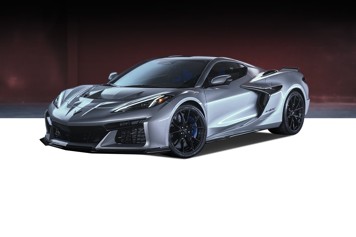 A Silver Chevrolet Corvette Z06 Sports Car with Black Accents, Aerodynamic Body Styling, and Glossy Black Wheels Positioned Against a Dark Background.