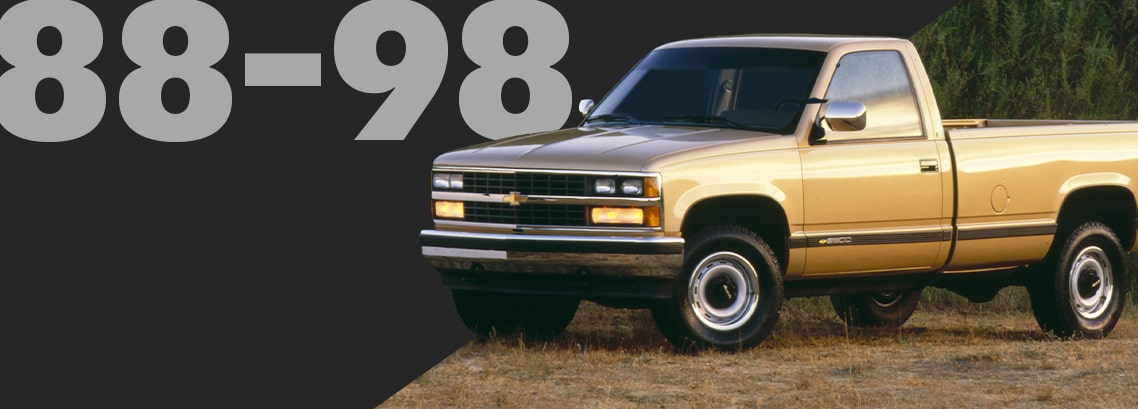 Three Quarters View of  a Gold Classic Chevrolet Pickup Truck Parked on Dry Grass