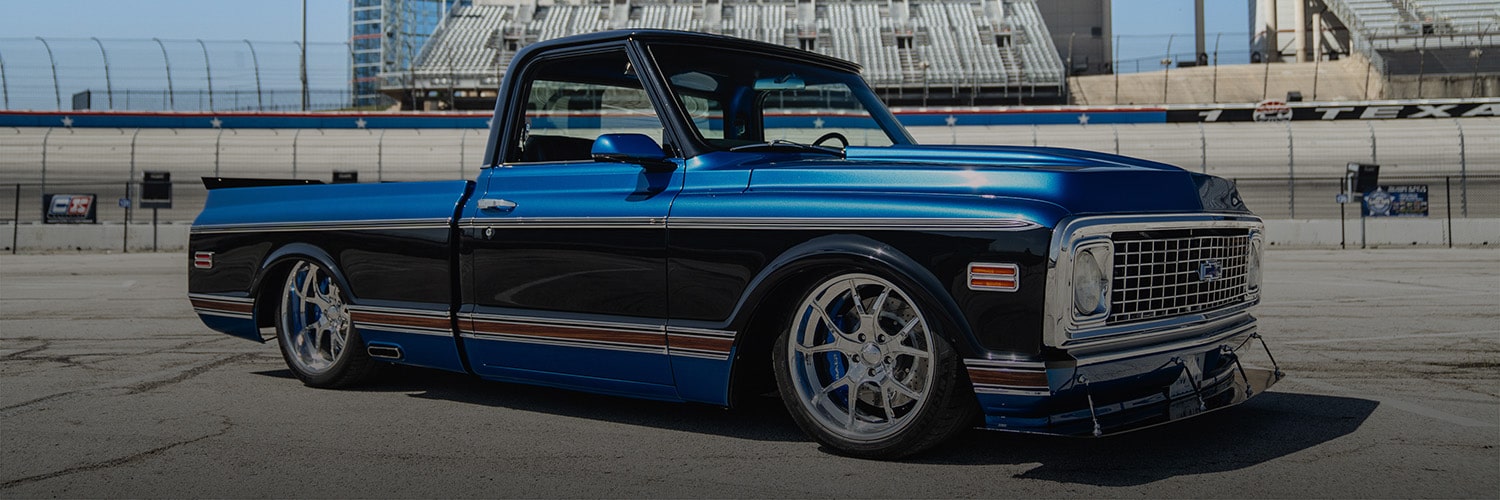 Side View of a Blue Classic Chevrolet Pickup Parked on a Racetrack