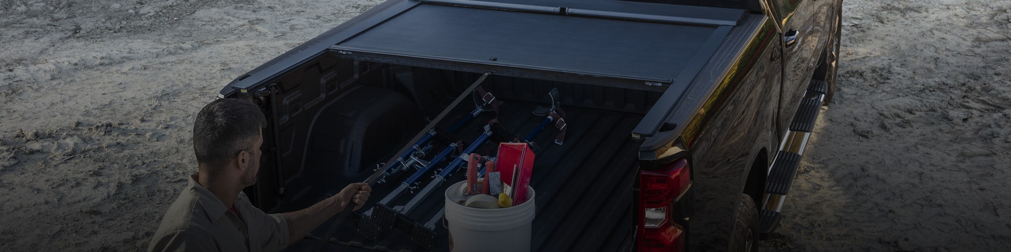 Man Standing at the Open Tailgate of a Black Chevy Pickup Truck