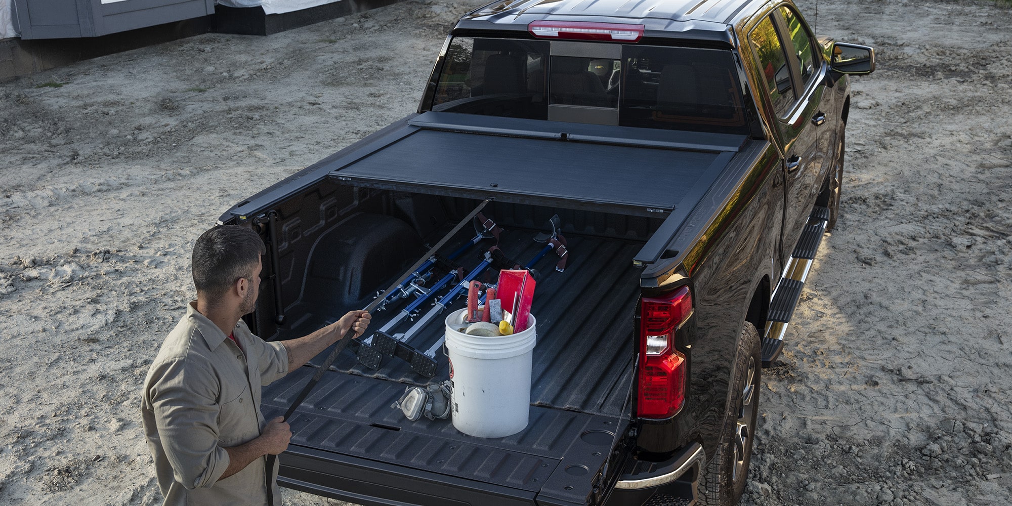 Man Standing at the Open Tailgate of a Black Chevy Pickup Truck