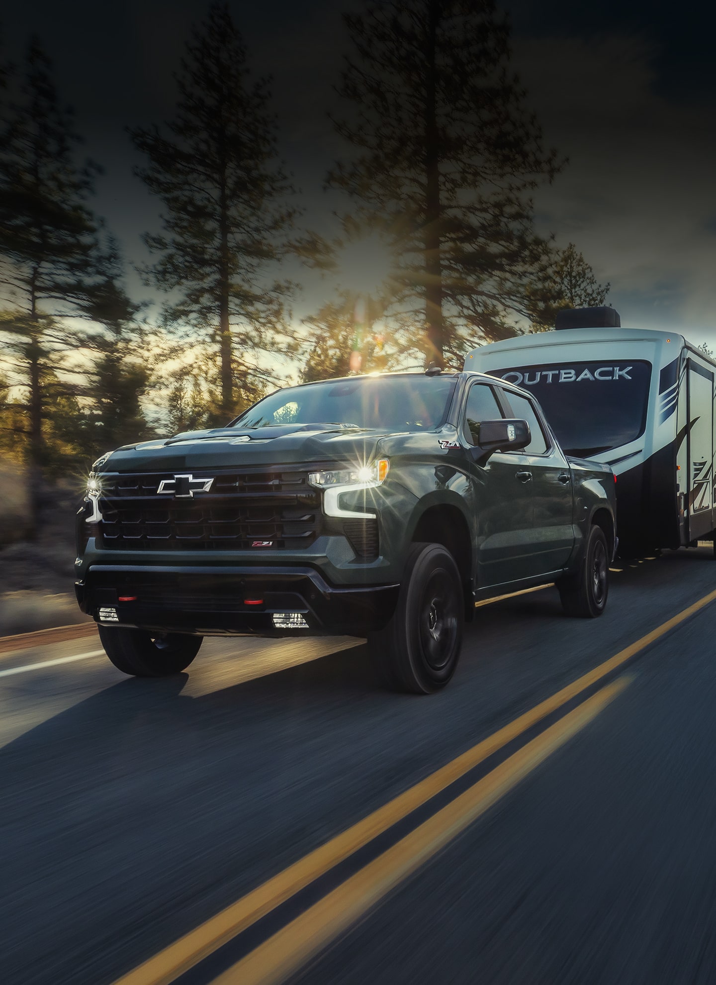 Black Chevrolet SUV Driving on Tree-Lined Suburban Road at Sunset