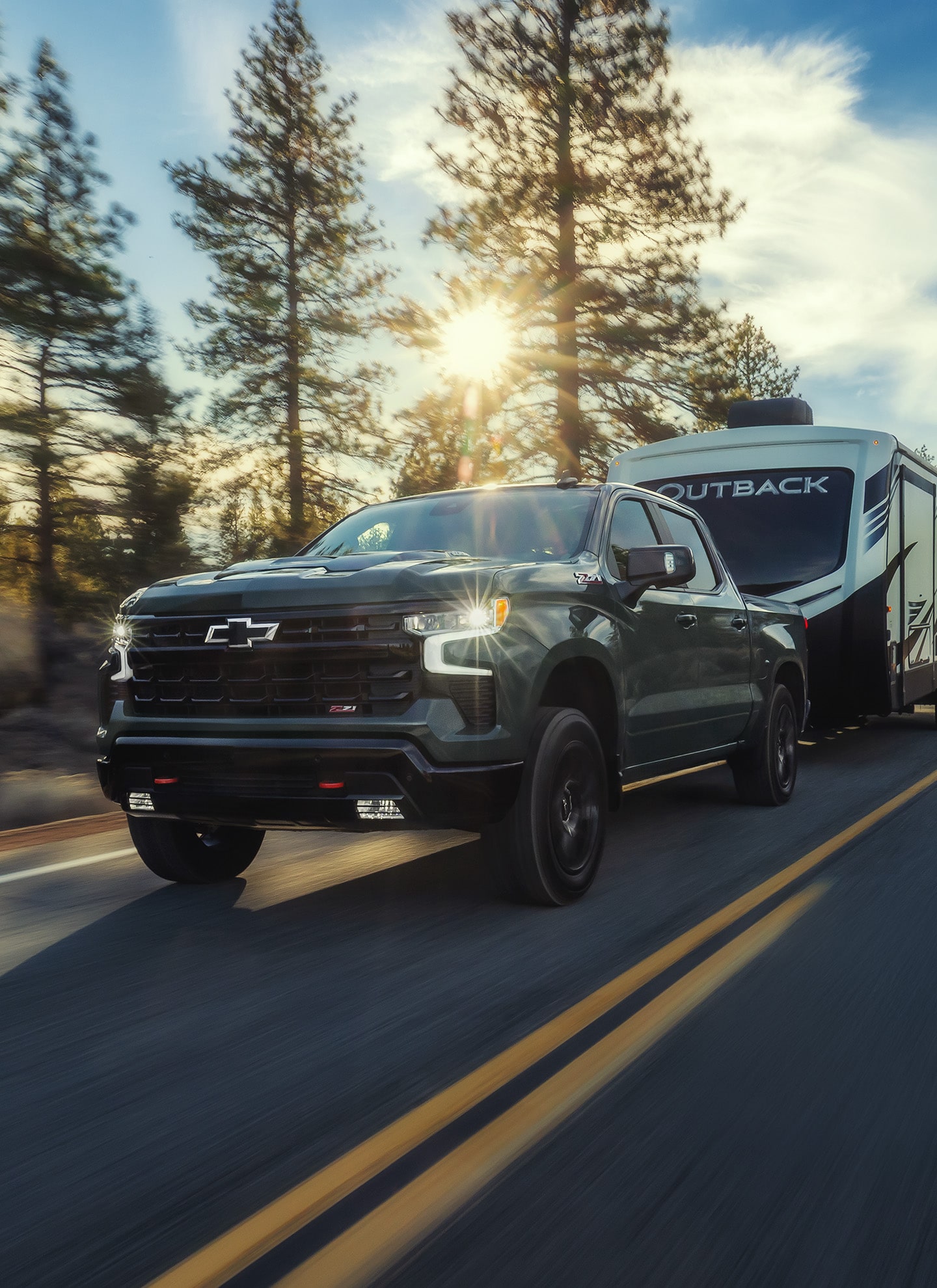 Black Chevrolet SUV Driving on Tree-Lined Suburban Road at Sunset