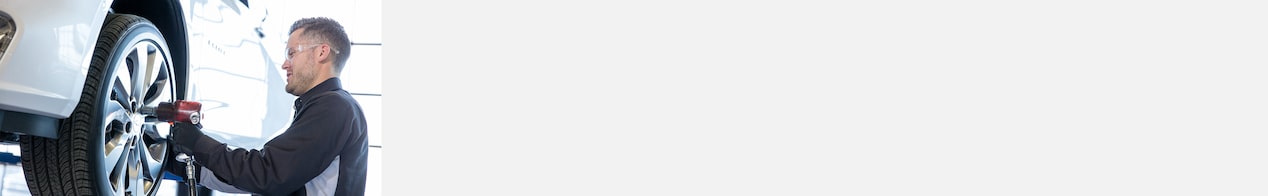 Technician Installing Front Left Tire of Vehicle