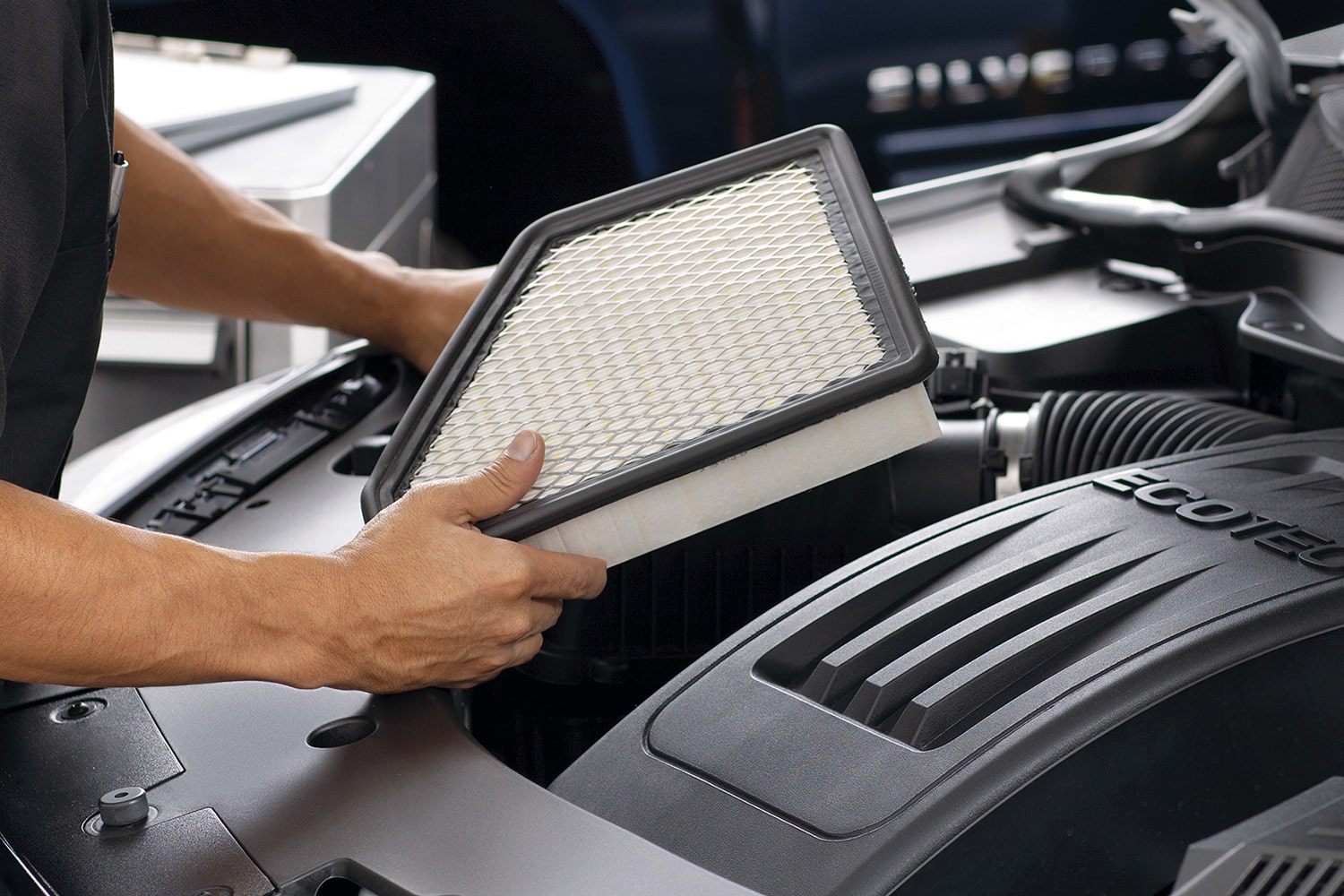 Two Green and White Chevrolet Vehicles on a Plain with Trees and Mountains Peaking from Behind