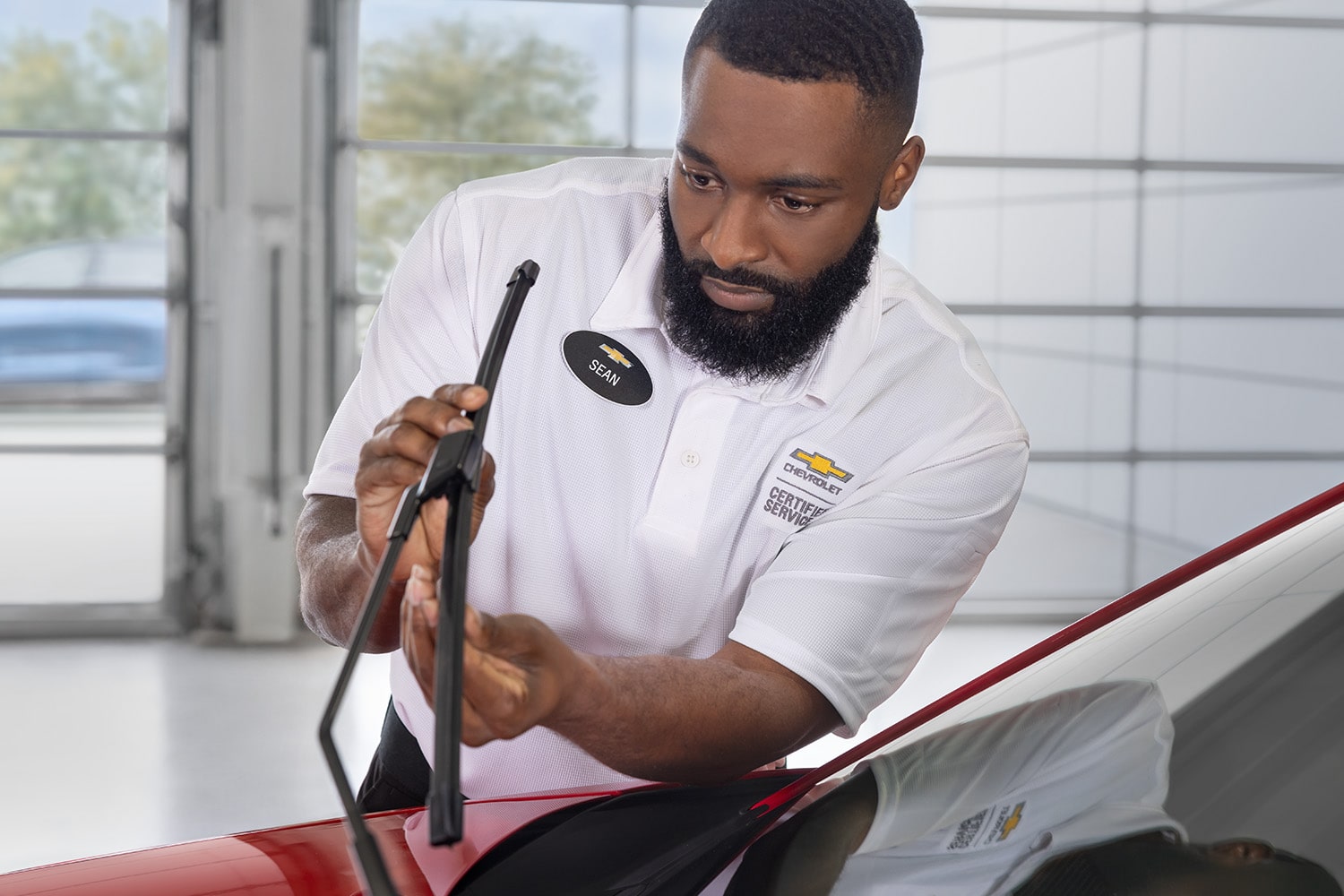 Two Green and White Chevrolet Vehicles on a Plain with Trees and Mountains Peaking from Behind