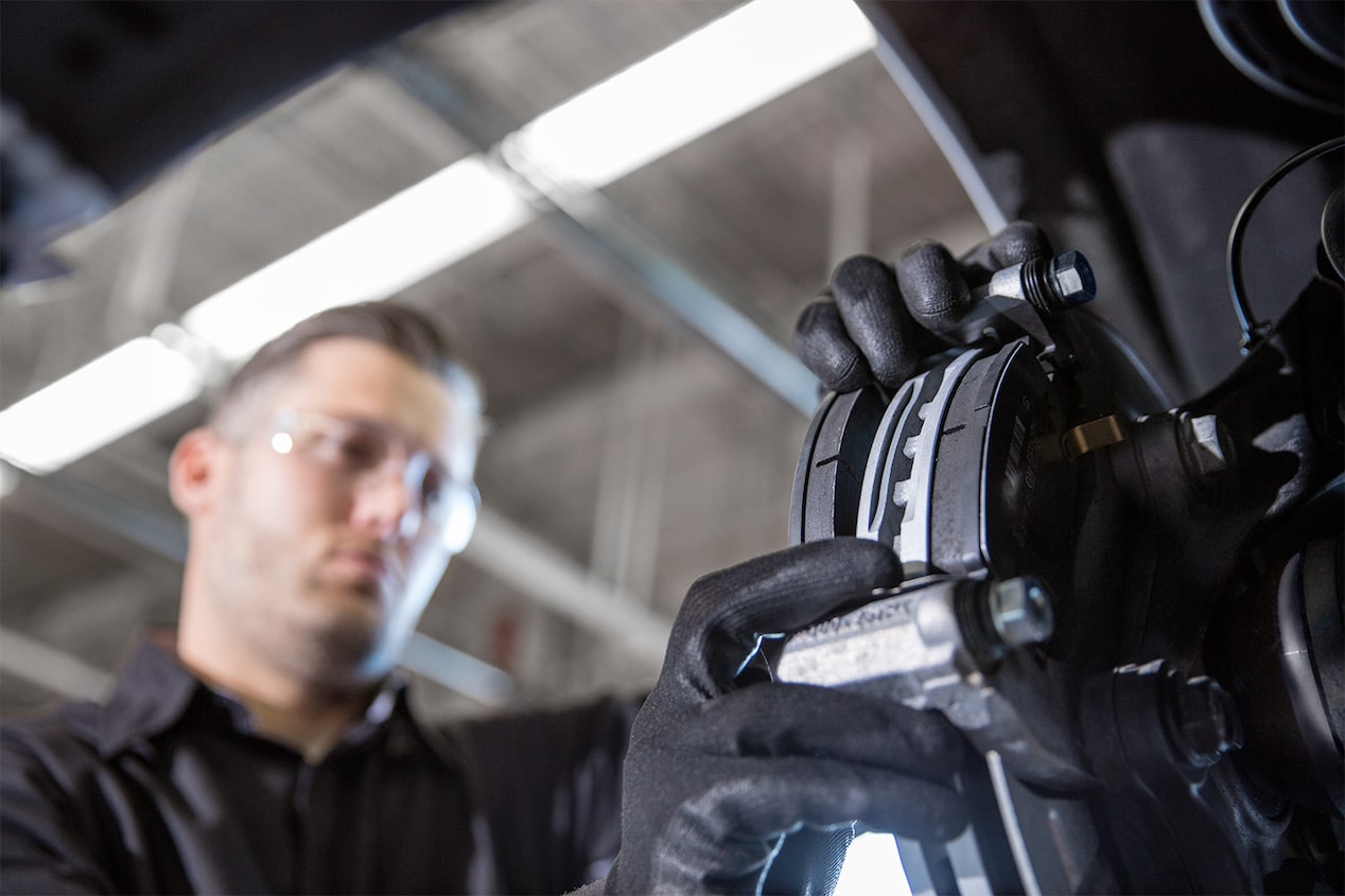 Receive up to a $40 Rebate Offer to the Left of a Man Working on Brakes