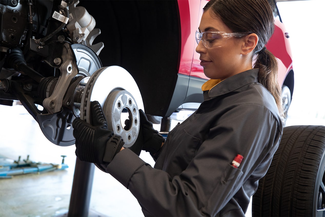 Receive up to a $40 Rebate Offer to the Left of a Woman Working on Vehicle Brakes