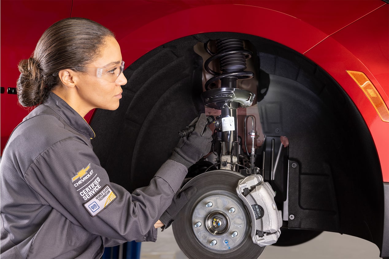 Receive up to an $80 Rebate Offer to the Left of a Picture of a Woman Working on the Front Brakes of a Vehicle