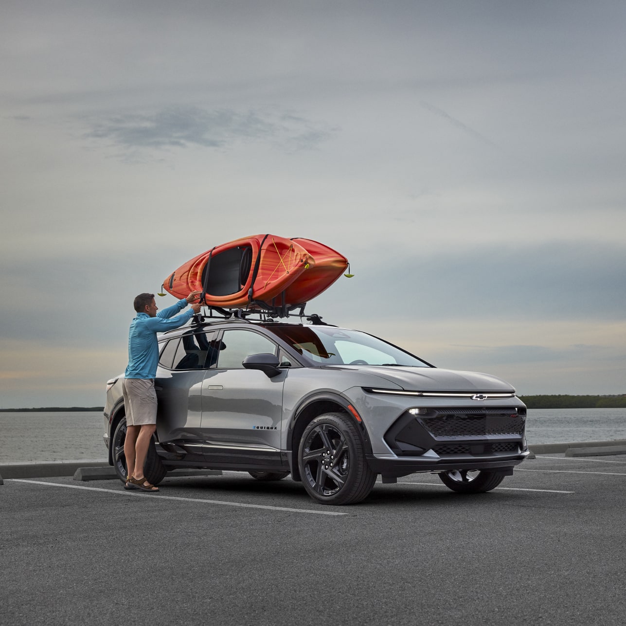 Person loading Kayaks on roof of Vehicle