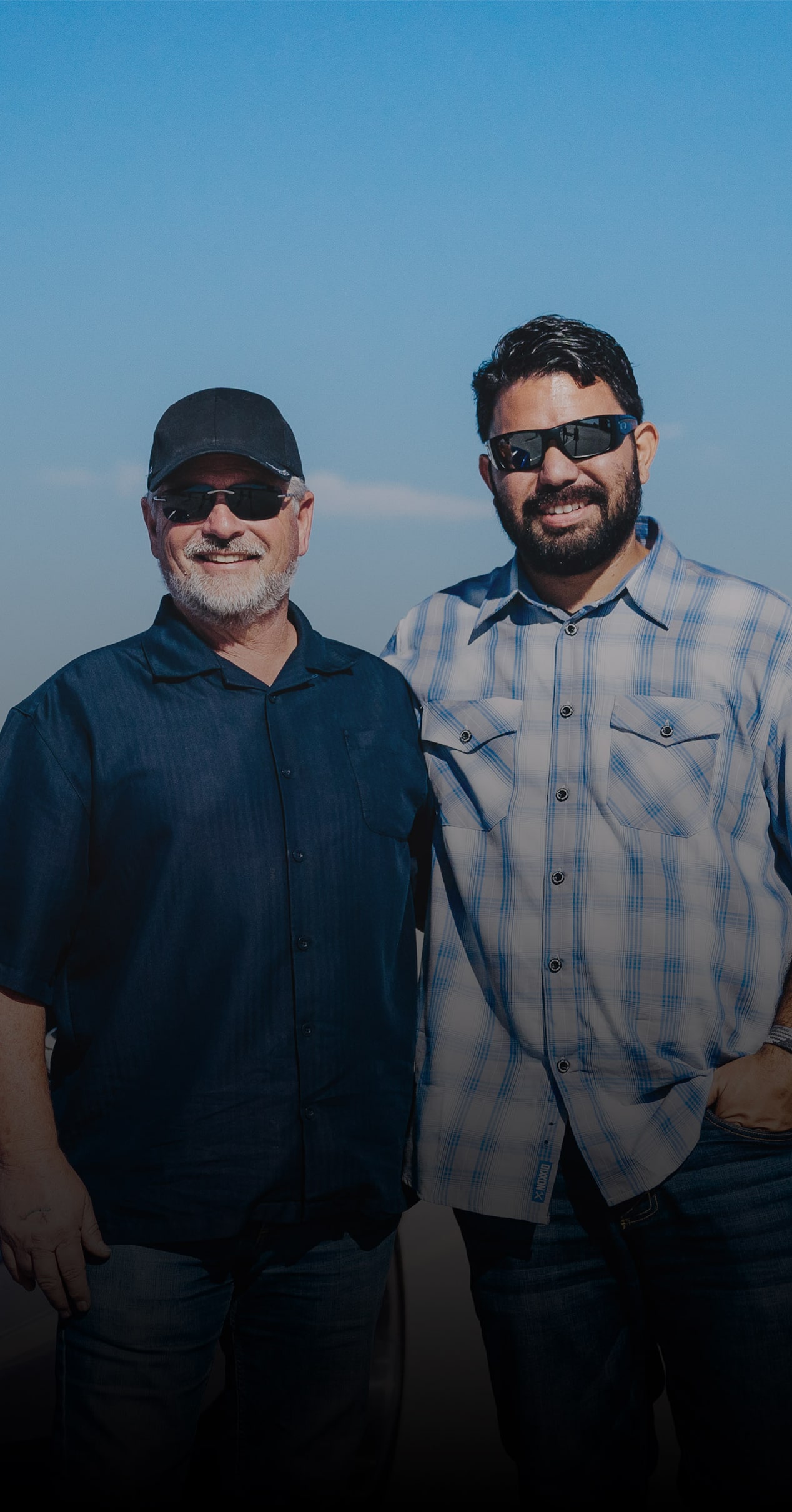 Mark Allen and Chris Greener Stand in Next to a Blue Chevy Car