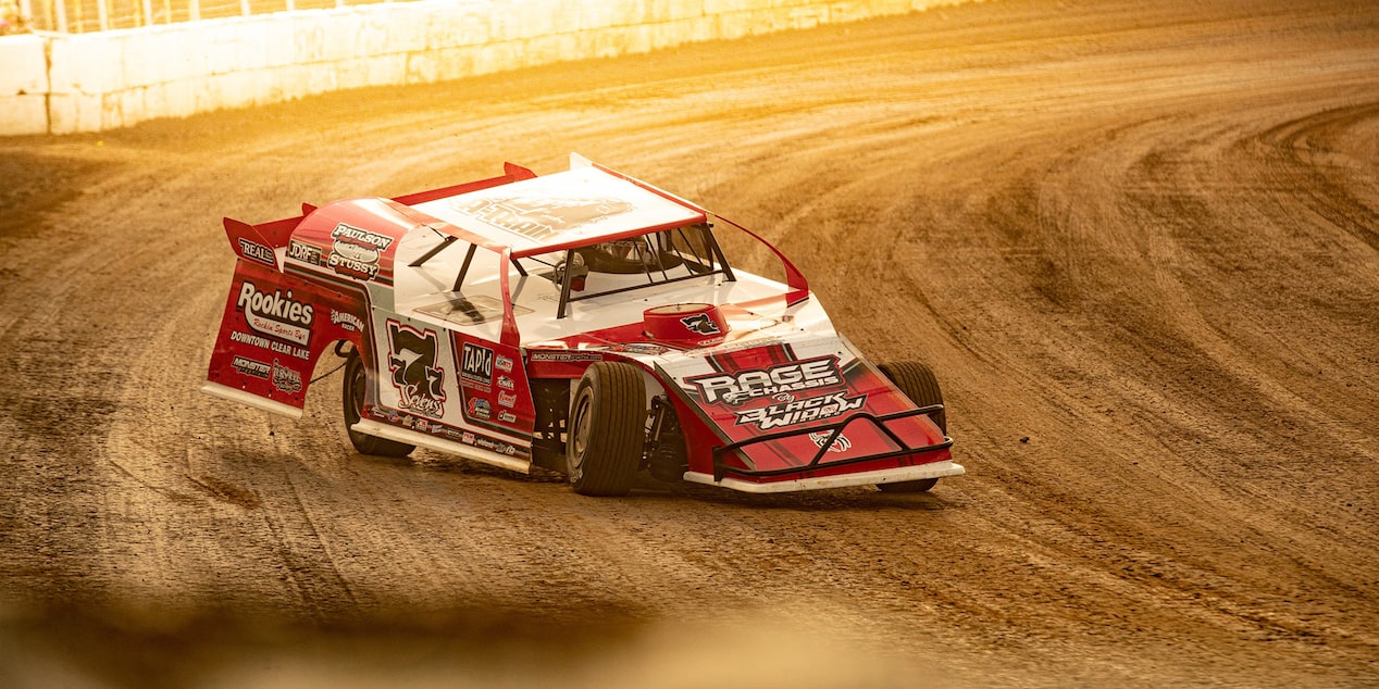 A Race Car Making a Turn on a Dirt Track