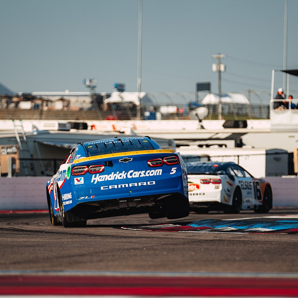 Blue and White Race Cars on a Race Track