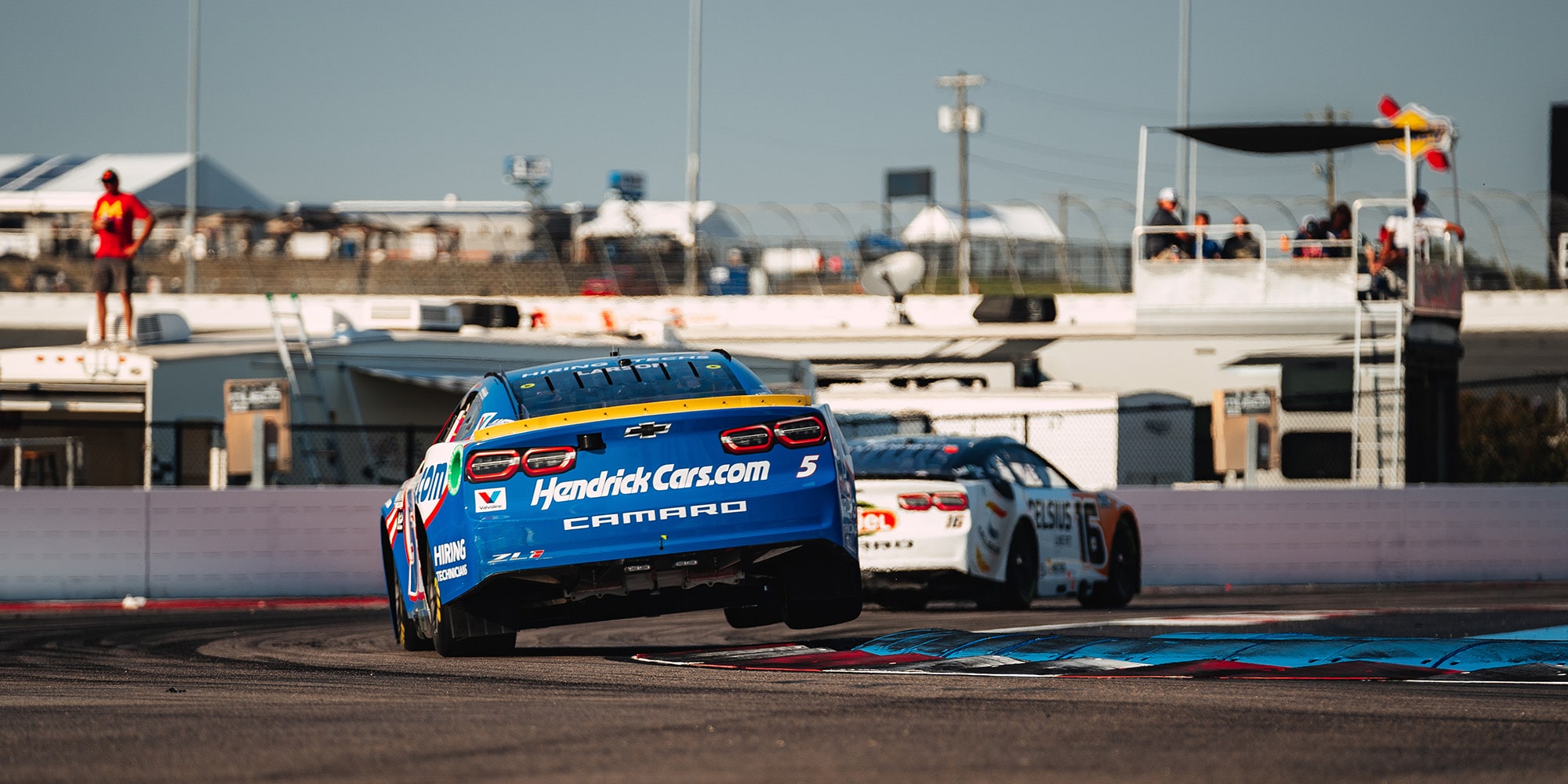 Blue and White Race Cars on a Race Track