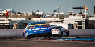 Blue and White Race Cars on a Race Track