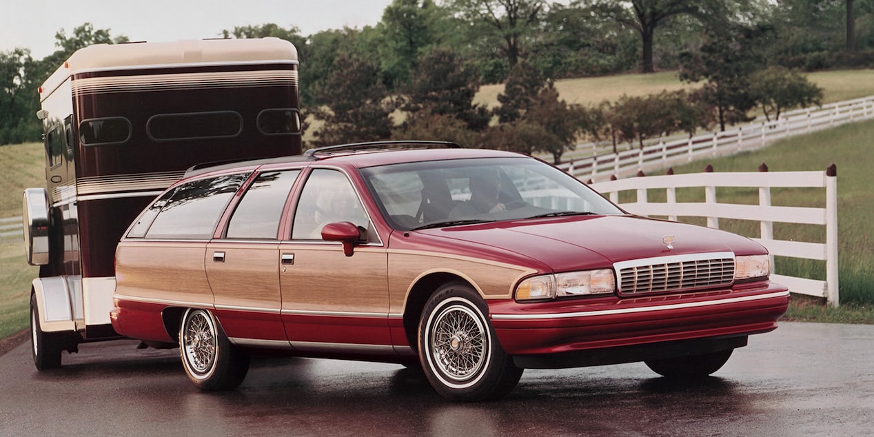 A Red 1994 Chevy Caprice Towing a Trailer on a Rural Property