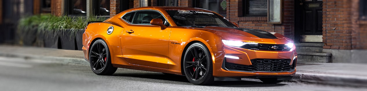 Front Three Quarters View of an Orange Chevrolet Camaro Parked on a City Street