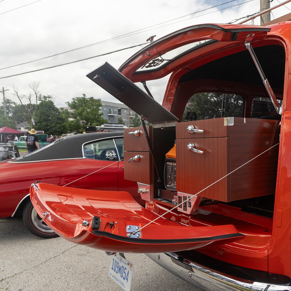 Orange Chevrolet Hot Rod Sports Vehicle With Open Trunk and Luggage Inside