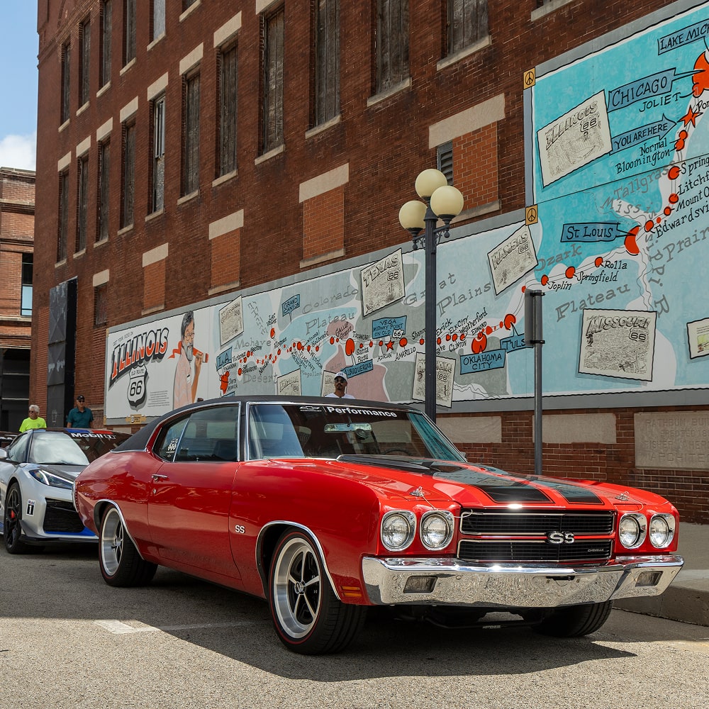 Classic Orange Chevrolet Car Parked Outside of Brick Building