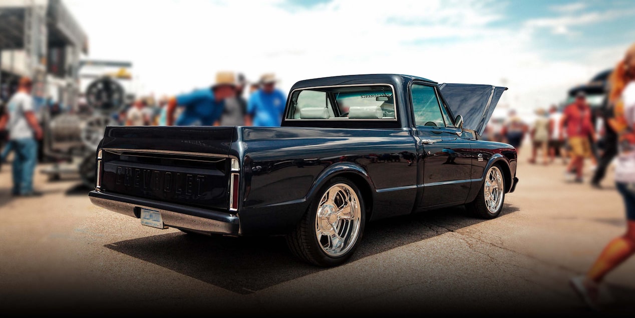 Rear Three Quarters View of a Vintage Black Chevy Pickup Truck at an Event with a Crowd Nearby