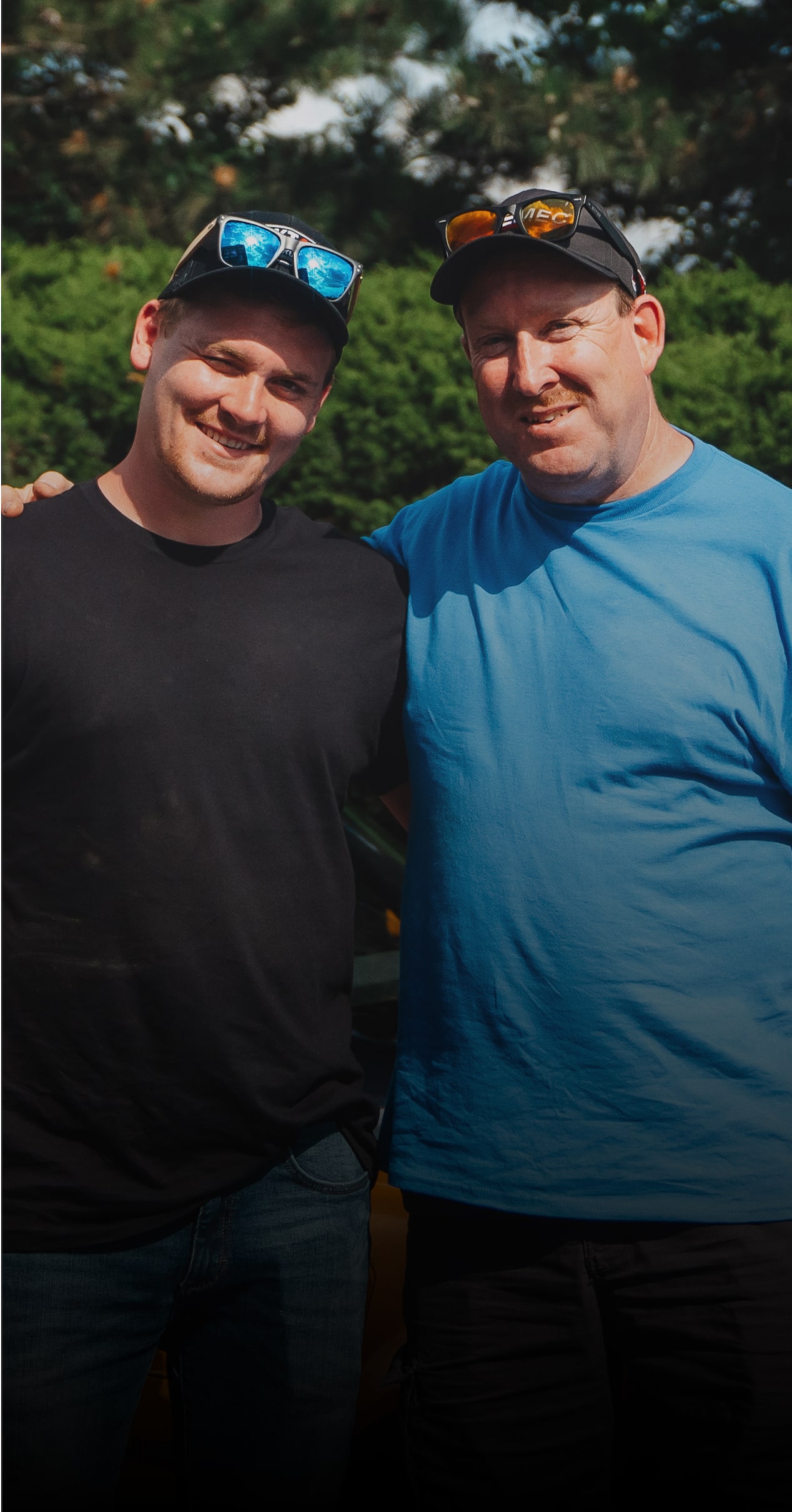 Two Men Pose in Front of a Yellow Chevy Sports Car