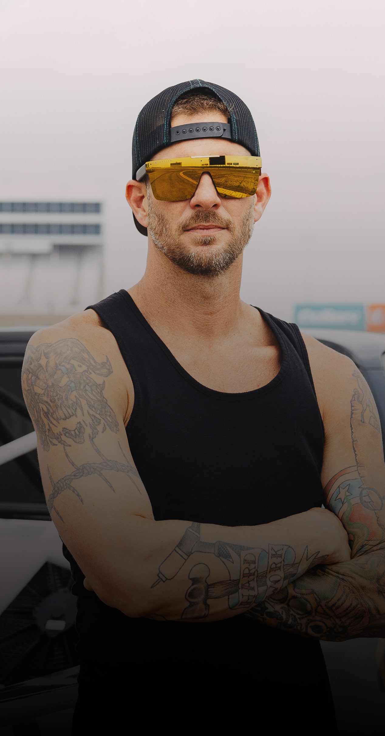 Mike Maciejack Stands in Front of a Chevy Pickup Truck on a Racetrack