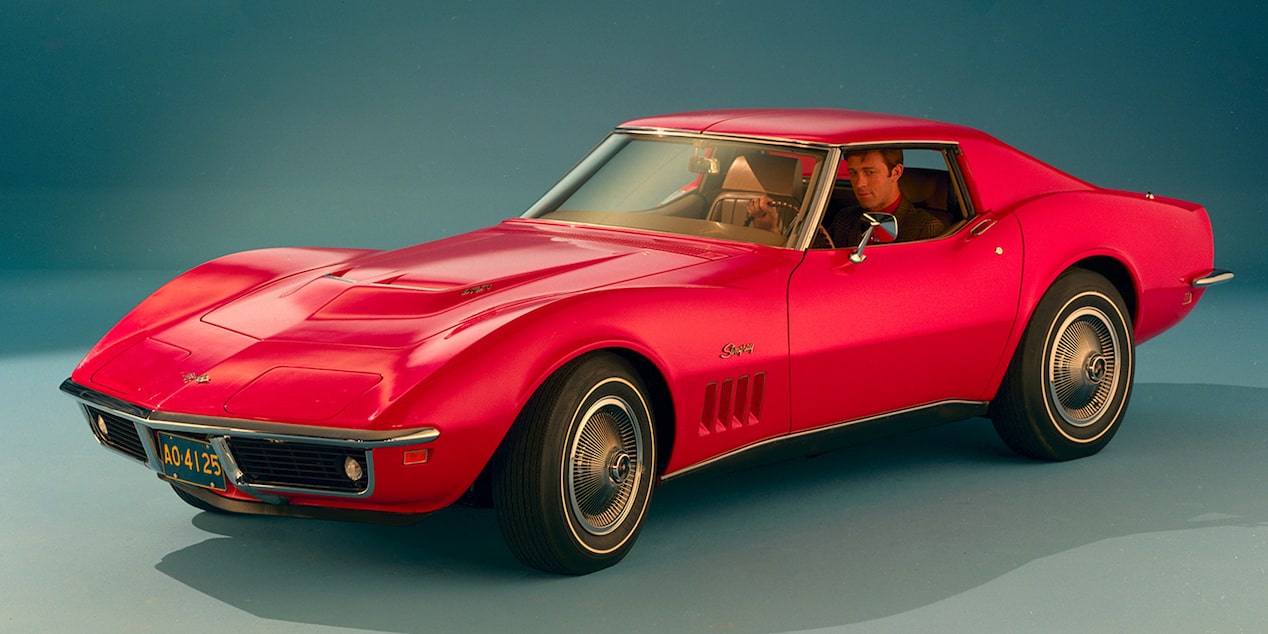 A Red 1969 Chevy Corvette Stingray Parked in a Stylized Showroom with Overhead Light Bearing Down