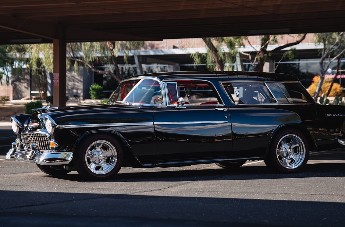 Side View of a Black 1955 Chevrolet Bel Air in a Parking Lot