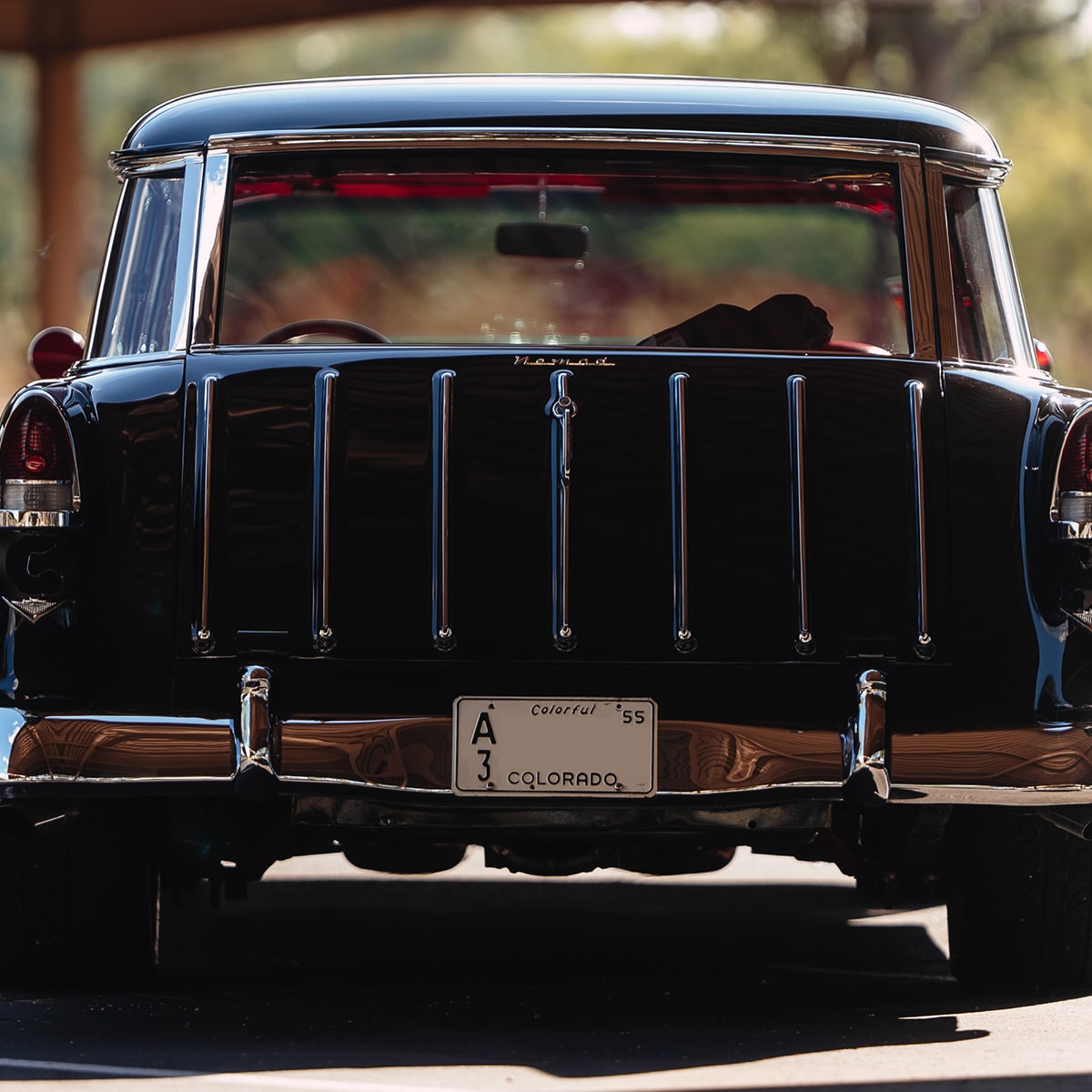 Front View of a Black 1955 Chevrolet Nomad in a Parking Lot