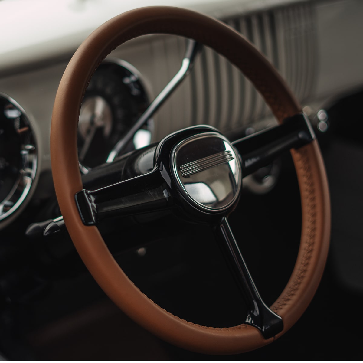 View of the Steering Wheel and Dashboard of a Blue 1955 Chevy Pickup Truck Seen Through the Driver's Side Window