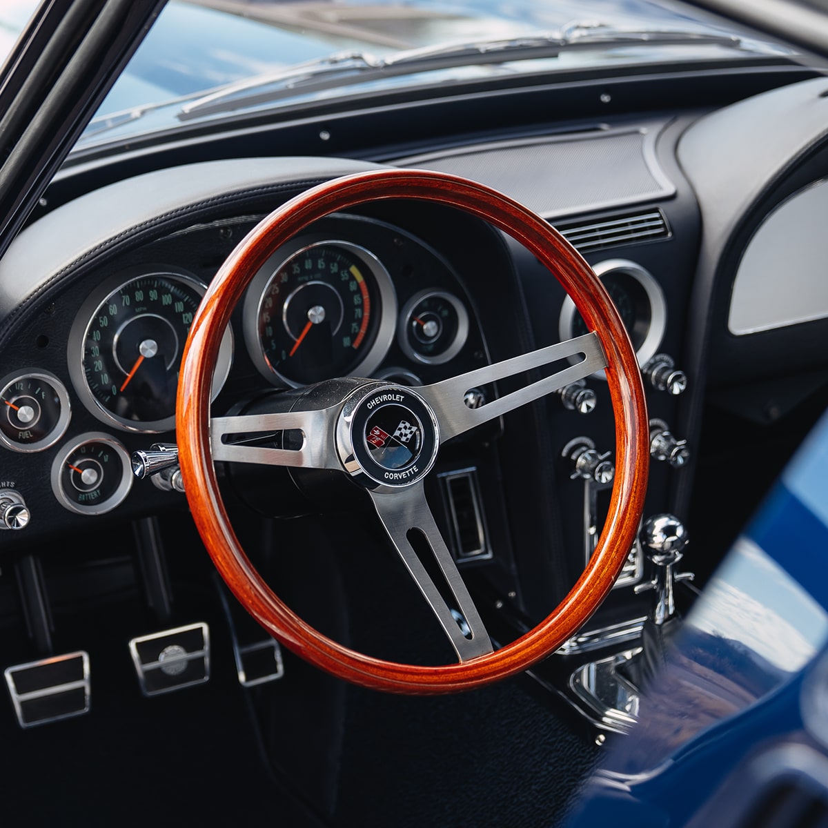 View of the Steering Wheel and Dashboard of a 1964 Chevy Corvette Stingray Through the Open Driver's Side Door