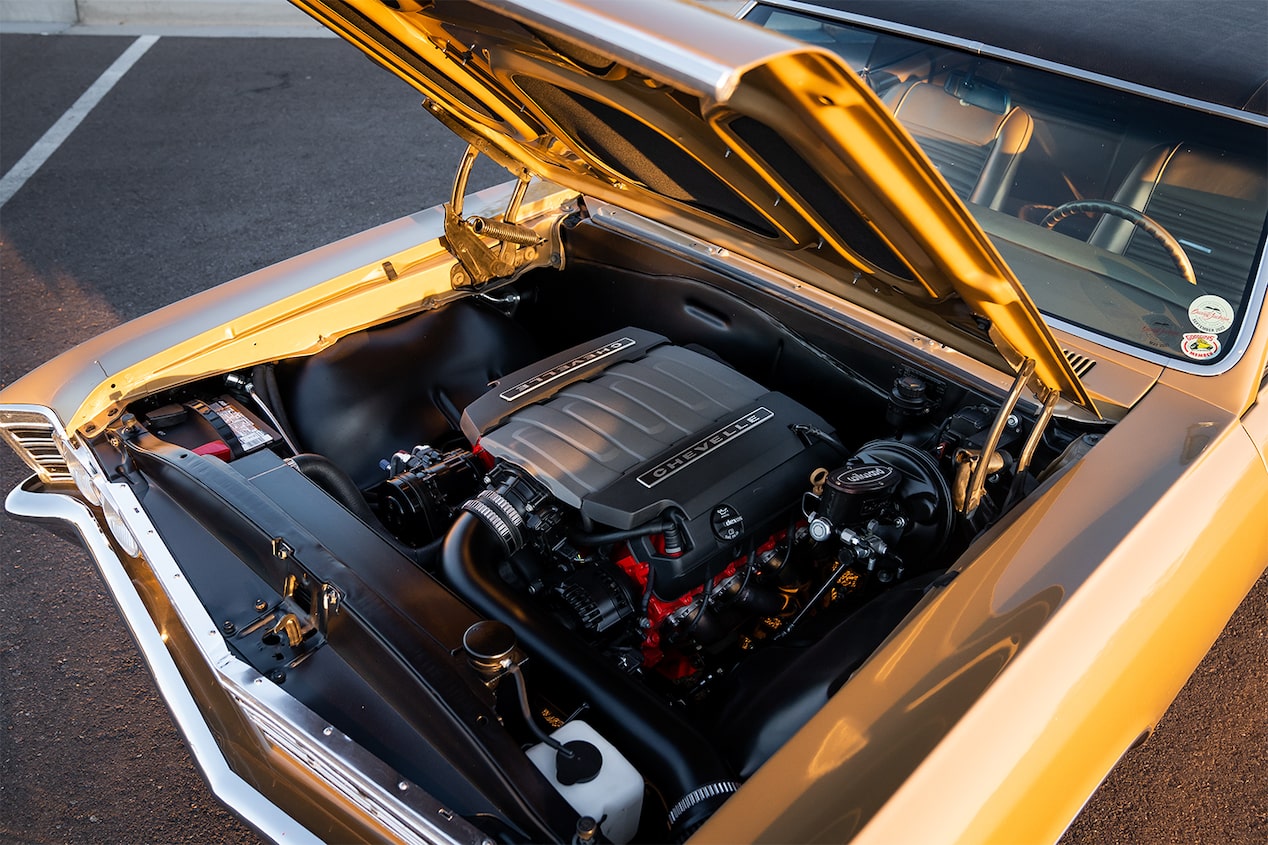 A Chevrolet Performance Parts LT1 Crate Engine Housed in the Engine Bay of a Gold 1967 Chevy Malibu with an Open Hood