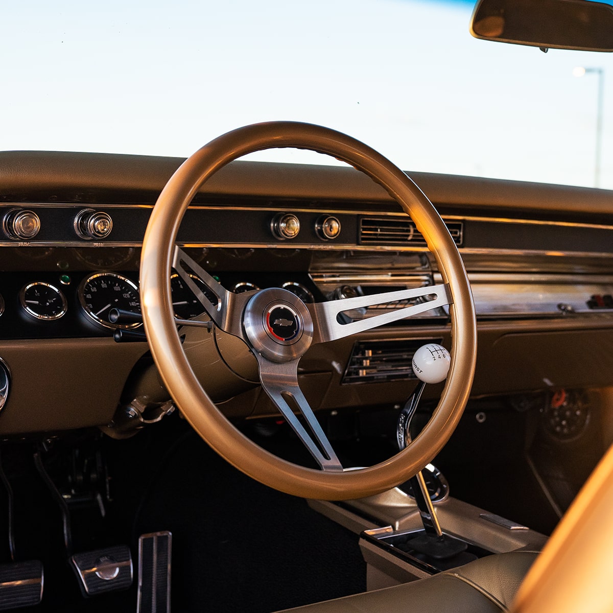 Steering Wheel and Dashboard of a Gold 1967 Chevy Malibu Seen Through the Open Driver's Side Door