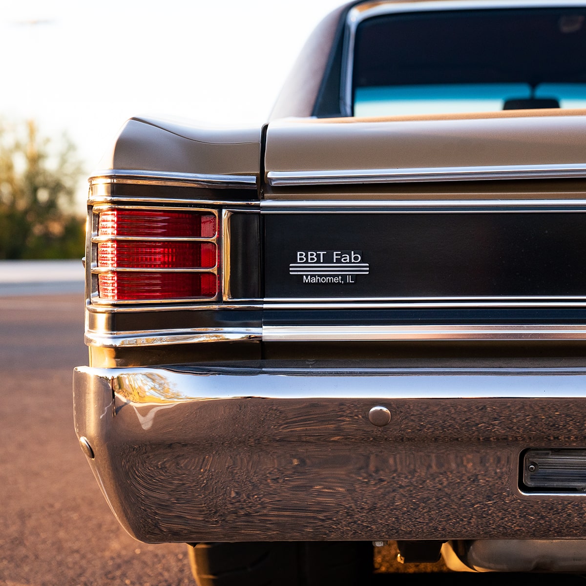 Rear View of the Left Half of a Gold 1967 Chevy Malibu in a Parking Lot