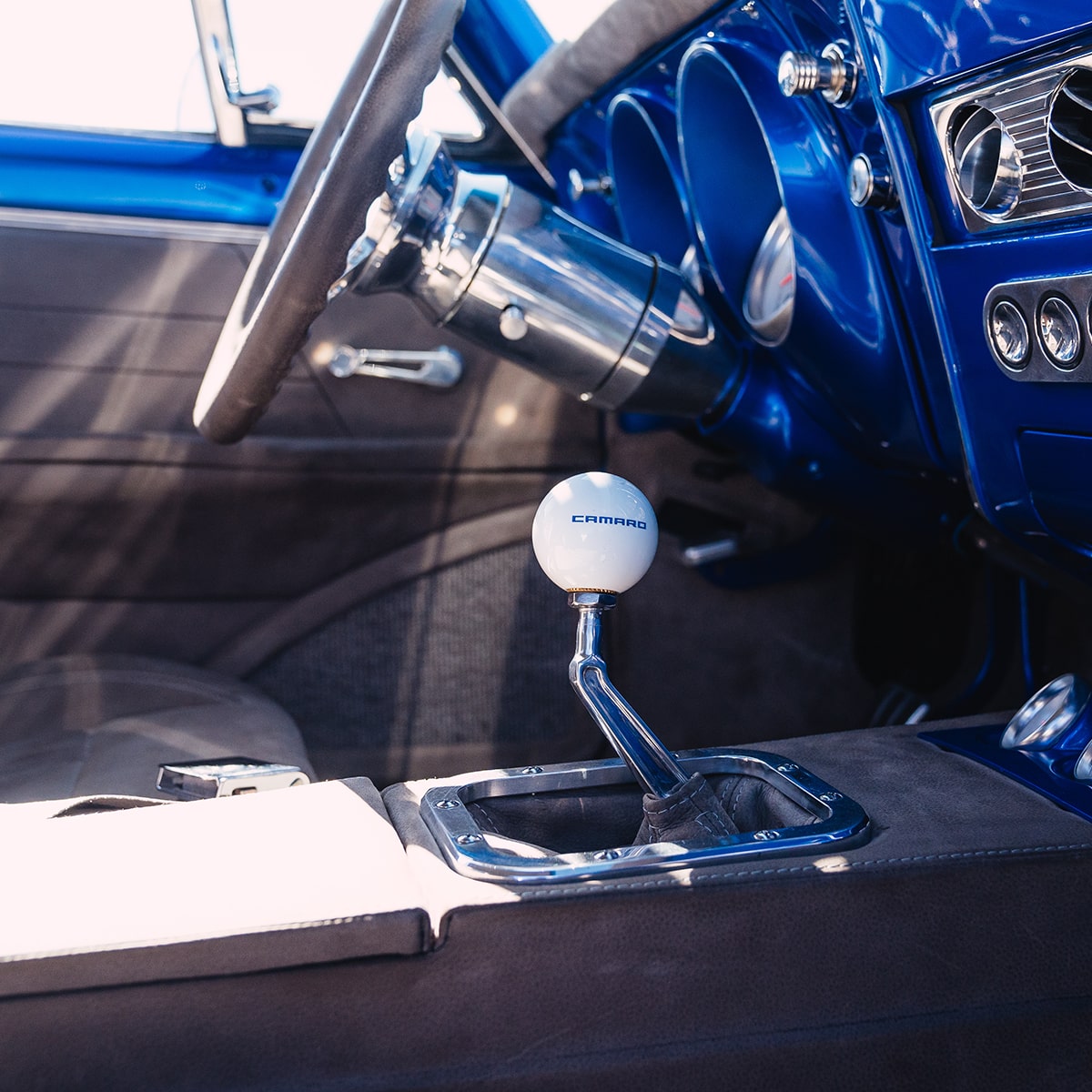 Interior View of the Gear Shift, Steering Wheel, and Console in a 1967 Chevy Corvette Stingray with Blue Trim
