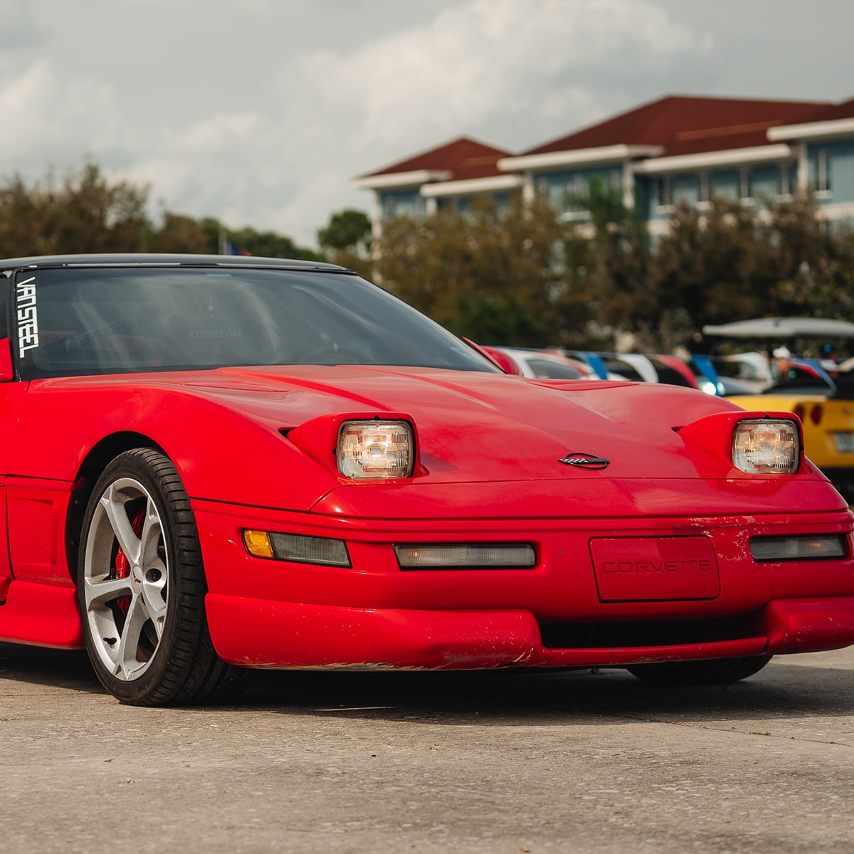Front Three Quarters View of a Red 1996 Chevy Corvette Parked at a Racing Event
