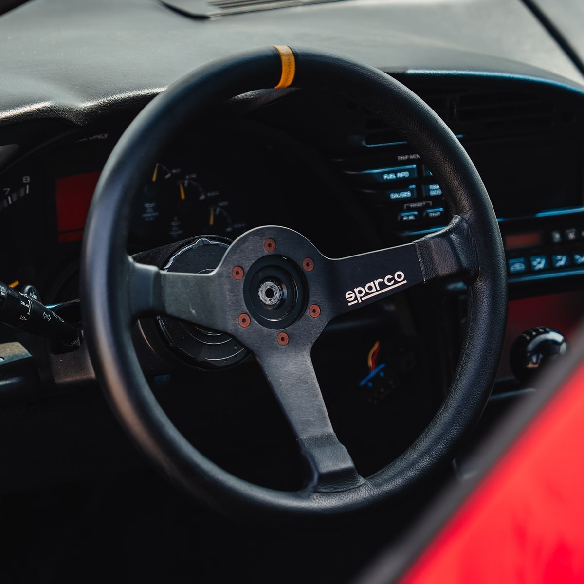 The Steering Wheel and Dashboard of a 1996 Chevy Corvette Seen Through the Driver's Side Window