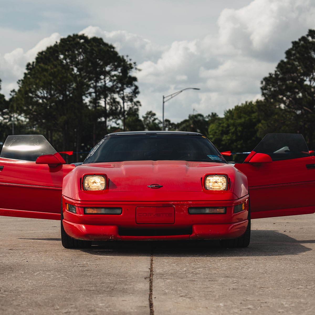 Front View of a Red 1996 Chevy Corvette with Both Doors Fully Open