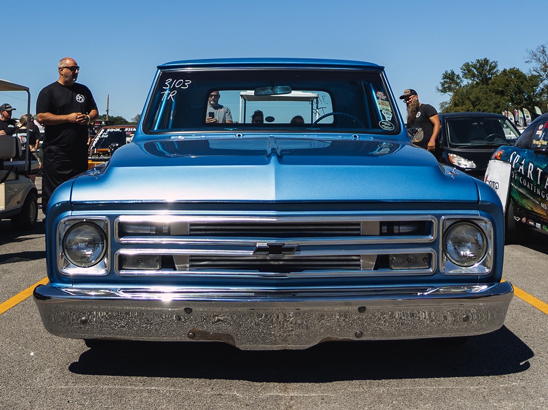 Front View of a Blue Vintage Chevy Pickup Truck in Excellent Condition with a Man Standing Near the Bed