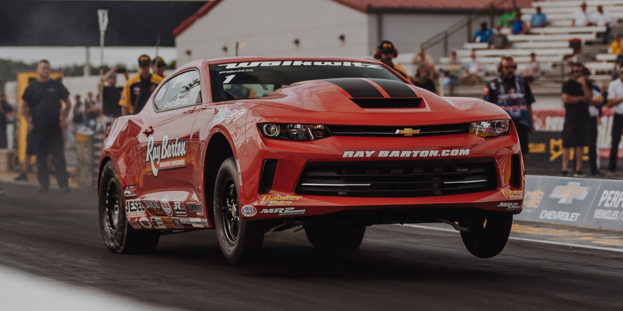 A COPO Camaro Racing on a Track with the Front Tires Up