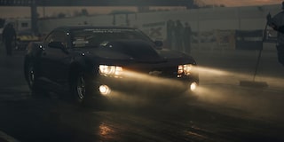 A COPO Camaro at Night with Its Front Lights On