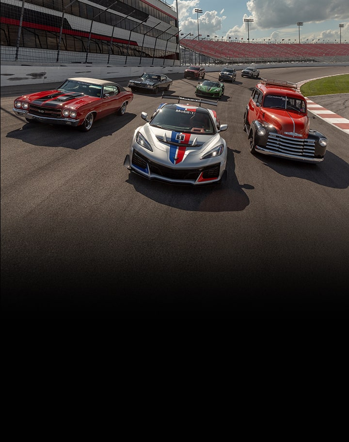 A Wide Angle of Classic and Modern Chevrolet Vehicles Lined up on a Drag Strip.