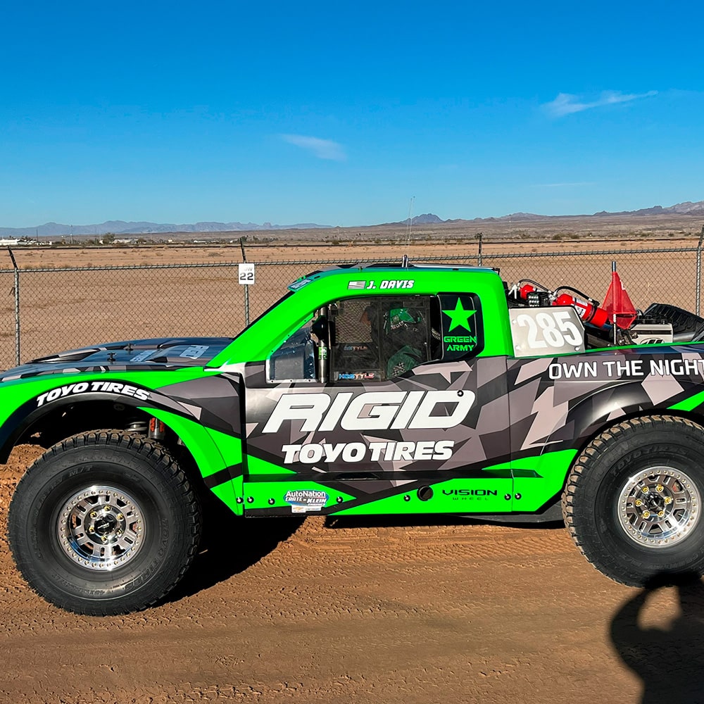 Left View of an Off-Roading Truck with Black, Green, and White Graphics