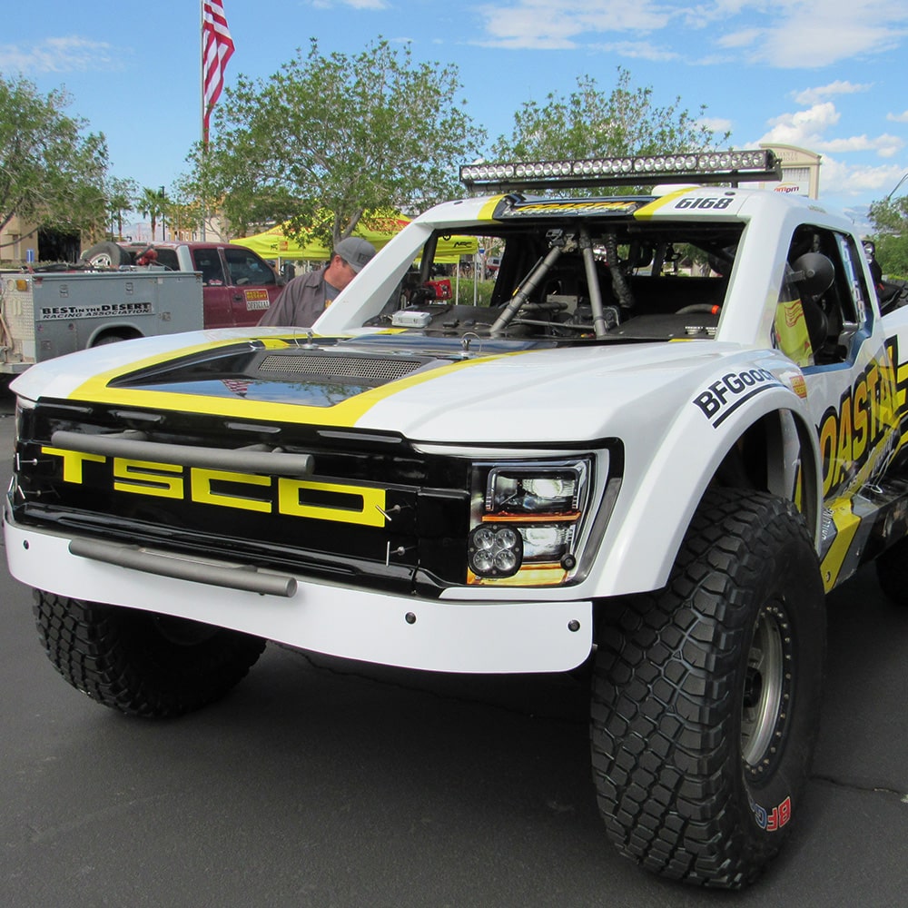 Front View of a White Chevy Off-Roading Truck with Black and Yellow Graphics