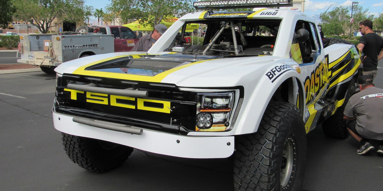Front View of a White Chevy Off-Roading Truck with Black and Yellow Graphics