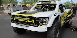 Front View of a White Chevy Off-Roading Truck with Black and Yellow Graphics